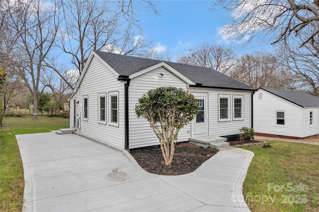 view of front of home featuring a front yard and roof with shingles