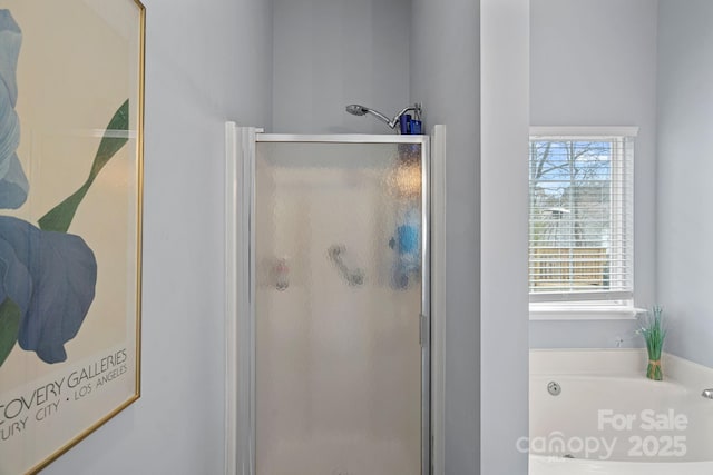 bathroom featuring a stall shower and a bath