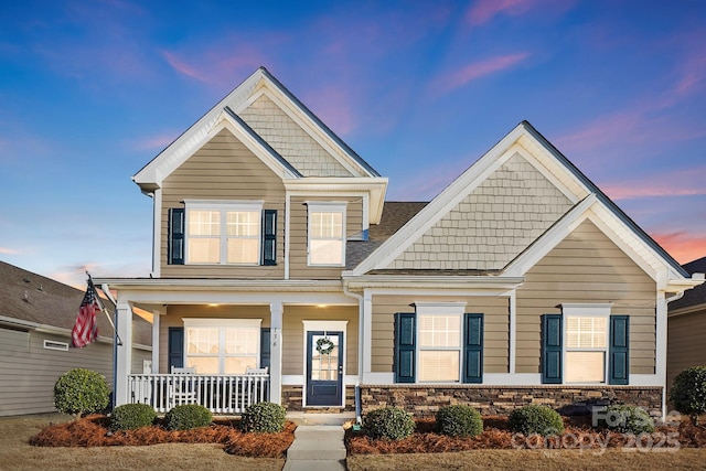 craftsman inspired home featuring a porch and stone siding