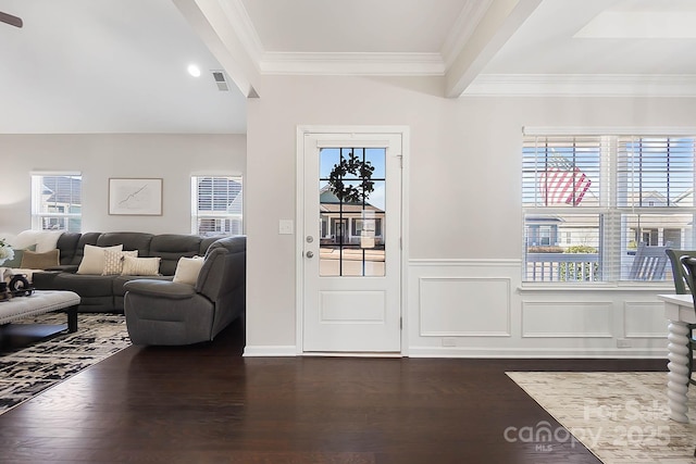 interior space with wainscoting, dark wood-style flooring, visible vents, and ornamental molding