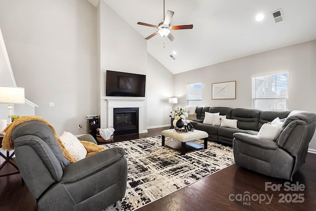 living area featuring visible vents, dark wood-style flooring, ceiling fan, and high vaulted ceiling