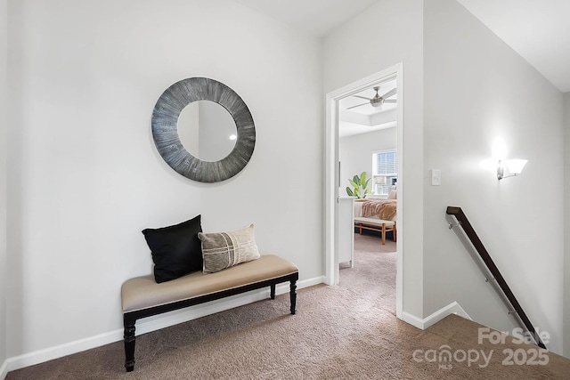 hallway featuring baseboards, carpet flooring, and an upstairs landing
