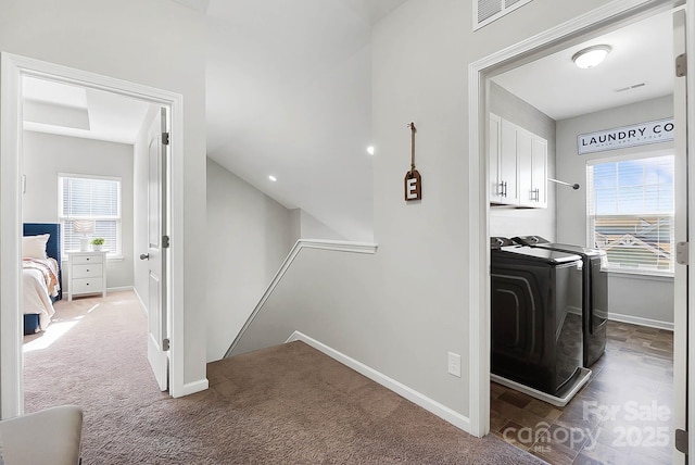 interior space featuring visible vents, cabinet space, baseboards, carpet floors, and separate washer and dryer