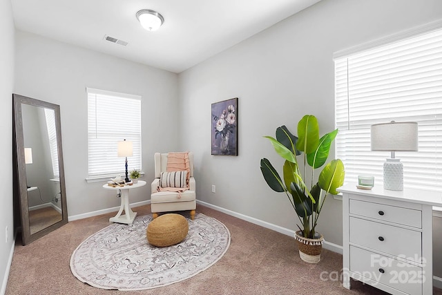 sitting room with carpet floors, baseboards, and visible vents