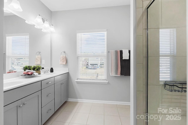 full bath featuring double vanity, tile patterned flooring, a sink, baseboards, and a shower with door