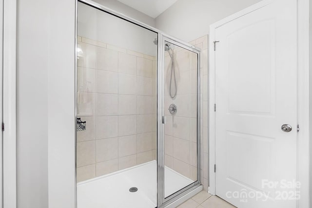 bathroom with tile patterned floors and a shower stall