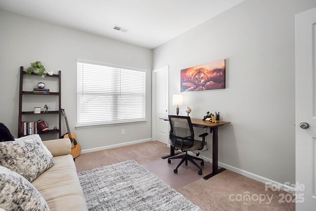 carpeted office space featuring visible vents and baseboards