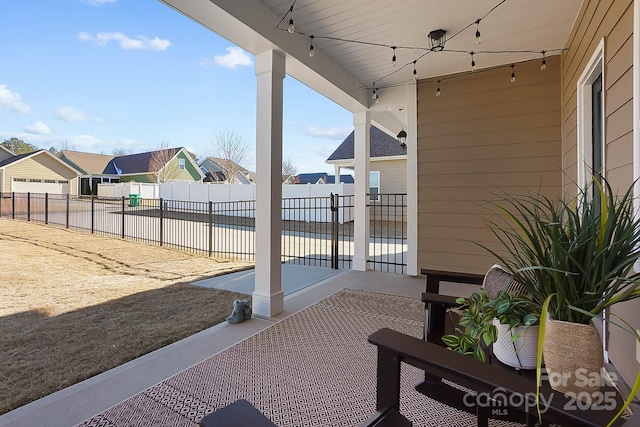 view of patio / terrace featuring a residential view, fence, and a water view
