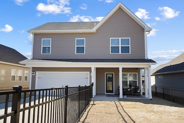 rear view of property featuring a garage, fence, roof with shingles, a porch, and driveway