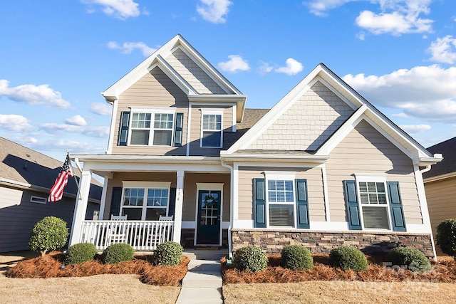 craftsman inspired home featuring a porch and stone siding