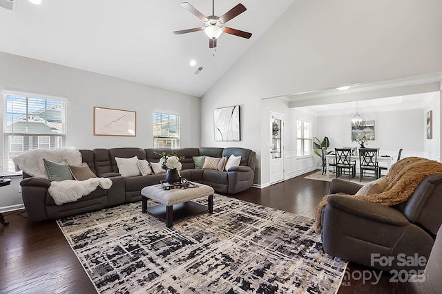 living area with baseboards, plenty of natural light, ceiling fan with notable chandelier, and dark wood-type flooring