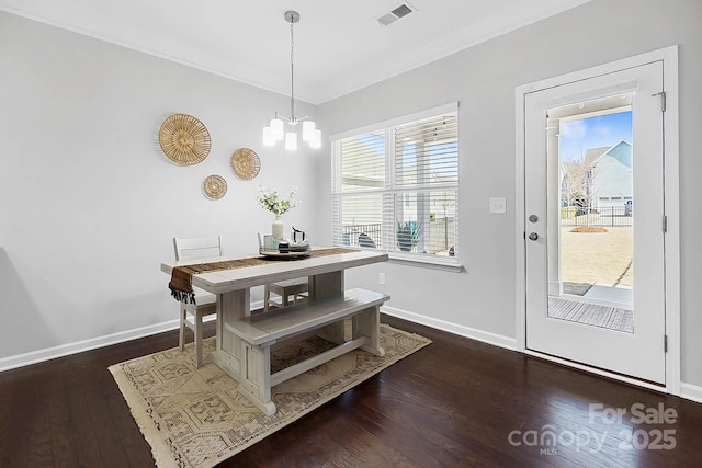 dining room with crown molding, baseboards, wood finished floors, and visible vents