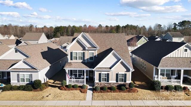 view of front of home with a residential view, covered porch, and stone siding