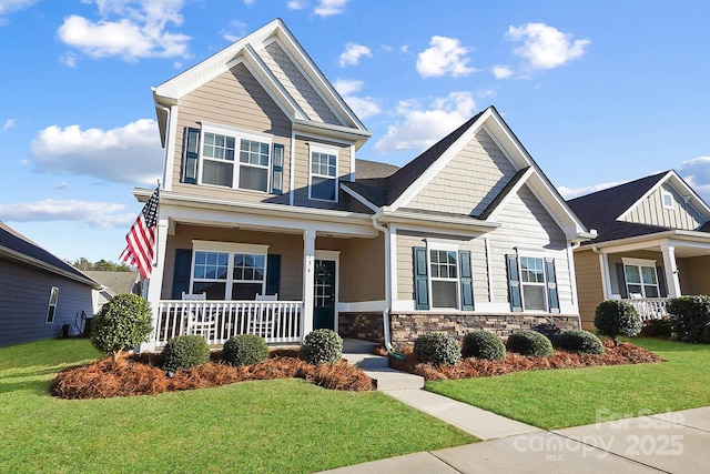 136 Kingston Dr, Locust, NC 28097 - craftsman house with covered porch, a front yard, and stone siding