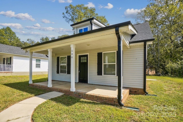 bungalow featuring a shingled roof, a porch, and a front yard