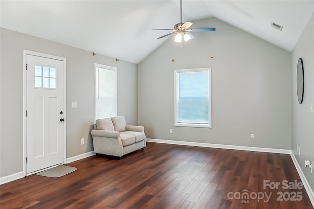 unfurnished room featuring dark wood finished floors, lofted ceiling, visible vents, a ceiling fan, and baseboards