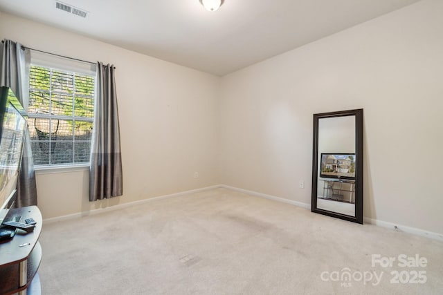 carpeted spare room with visible vents and baseboards