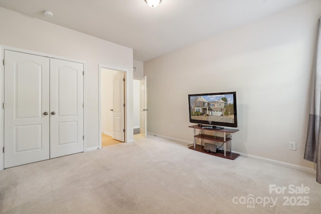 bedroom with carpet floors, baseboards, and a closet