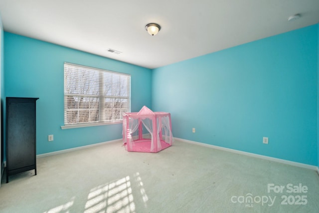 recreation room with carpet floors, visible vents, and baseboards