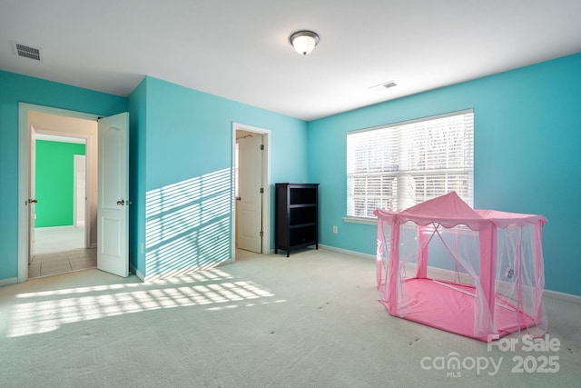 rec room with carpet, visible vents, and baseboards