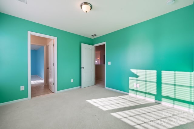 unfurnished bedroom with baseboards, visible vents, and carpet flooring