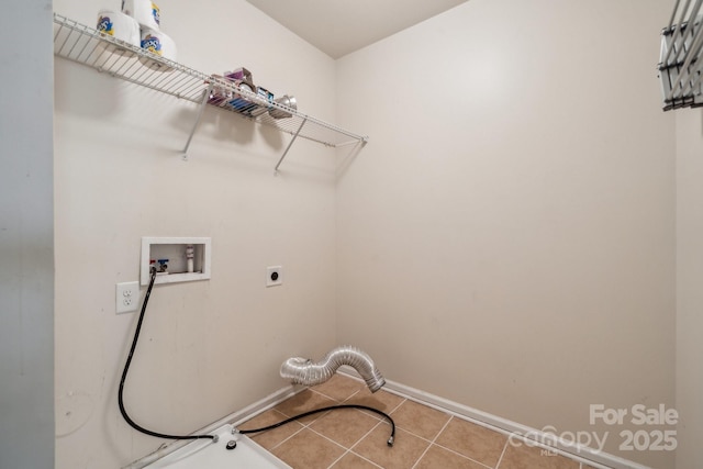 clothes washing area featuring hookup for a washing machine, hookup for an electric dryer, laundry area, baseboards, and tile patterned floors