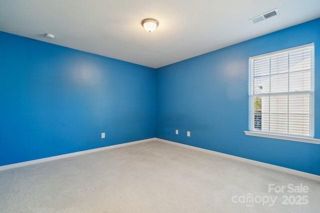 carpeted empty room with visible vents and baseboards