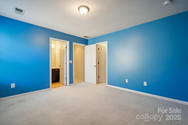 unfurnished bedroom with carpet floors, ensuite bath, visible vents, and baseboards