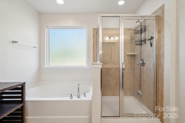 bathroom with a shower stall, a bath, and recessed lighting