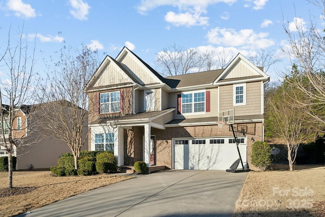 craftsman house with a garage, driveway, brick siding, and board and batten siding