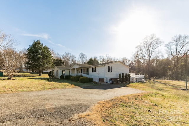 view of front facade featuring aphalt driveway and a front yard