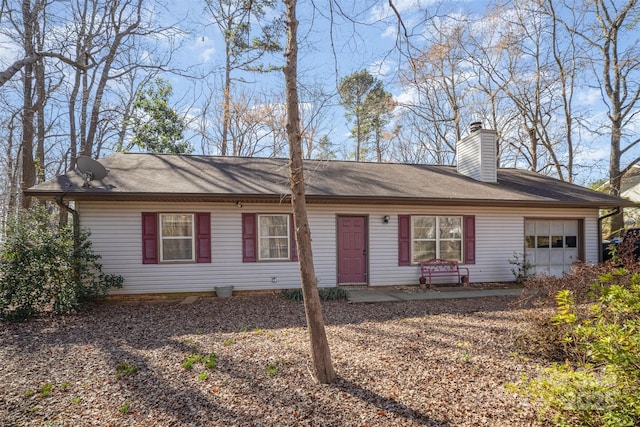 single story home with a garage and a chimney