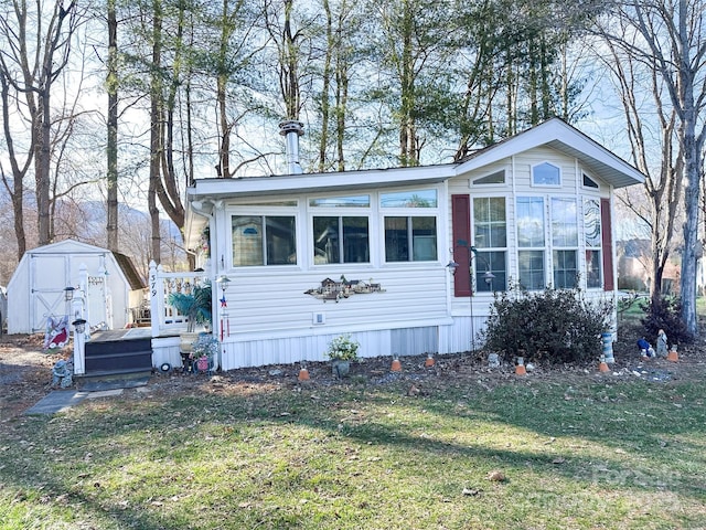 view of front of home with a shed, an outbuilding, and a front yard