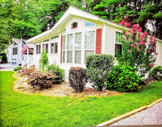 view of side of home with a yard and a sunroom