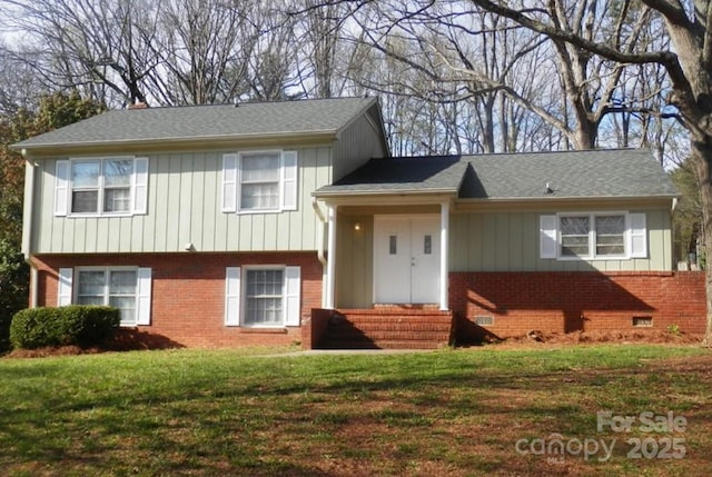 split level home with entry steps, crawl space, brick siding, and a front yard