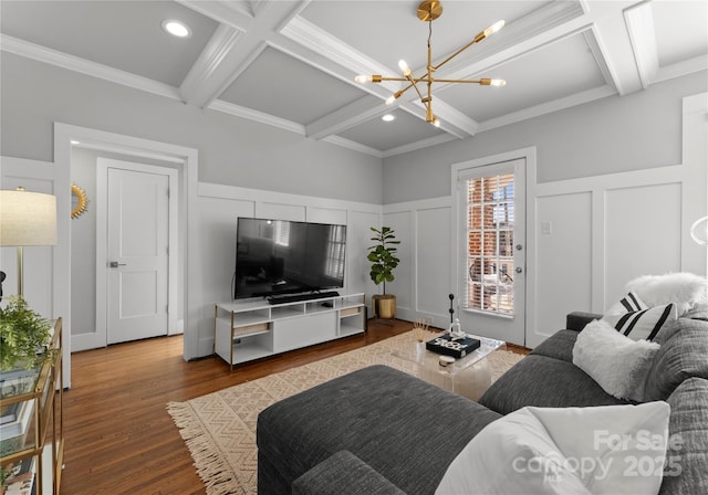 living area with coffered ceiling, a decorative wall, and wood finished floors