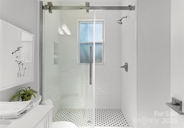 bathroom with a stall shower, vanity, and toilet