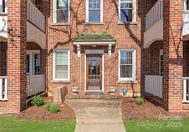 entrance to property featuring brick siding