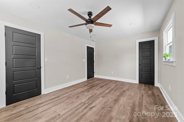 foyer entrance featuring ceiling fan, wood finished floors, and baseboards