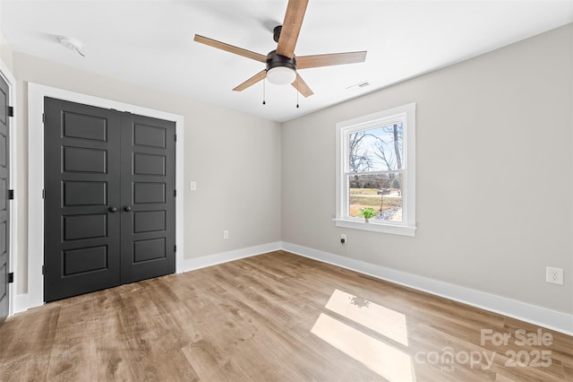 foyer with ceiling fan, wood finished floors, visible vents, and baseboards