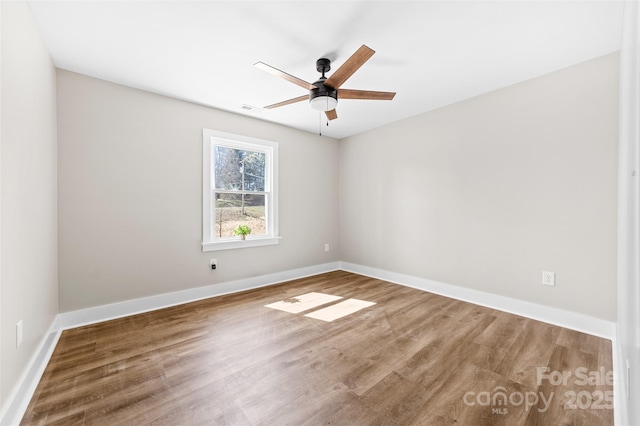 unfurnished room with baseboards, a ceiling fan, and wood finished floors