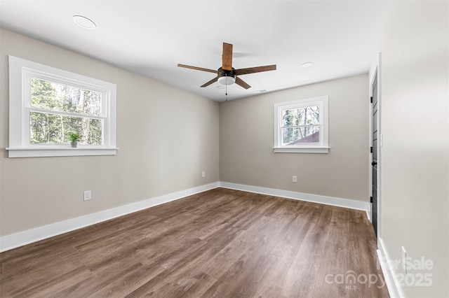 empty room with ceiling fan, baseboards, and wood finished floors