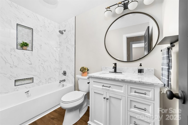 bathroom featuring toilet, shower / bathtub combination, wood finished floors, and vanity