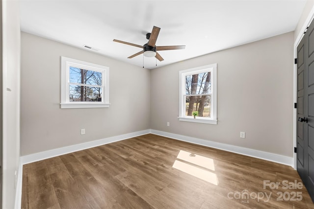 unfurnished bedroom with ceiling fan, wood finished floors, visible vents, and baseboards