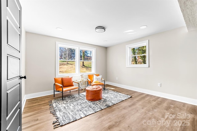 sitting room featuring a healthy amount of sunlight, baseboards, and wood finished floors