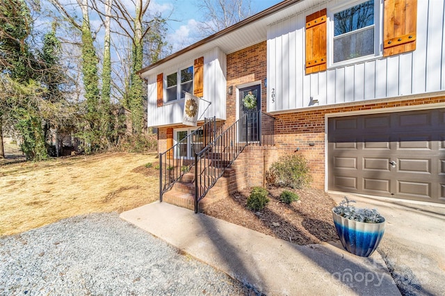 doorway to property with brick siding, board and batten siding, and an attached garage