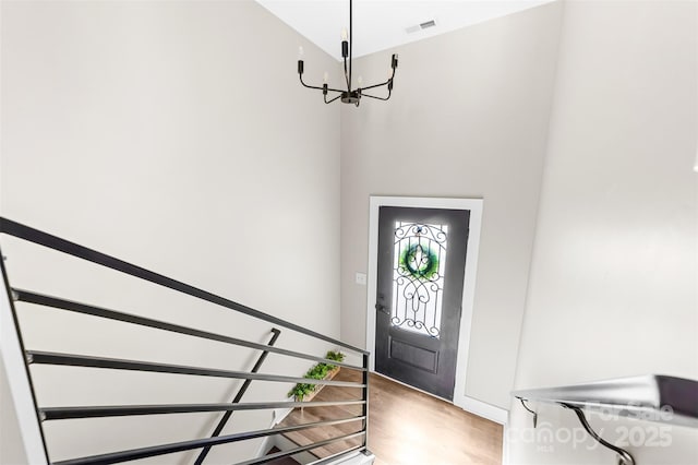 foyer entrance featuring light wood-style floors, a chandelier, and visible vents