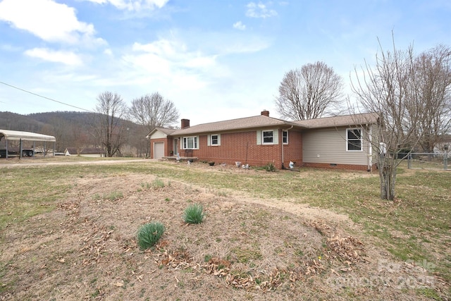 back of house featuring a chimney, brick siding, crawl space, and an attached garage