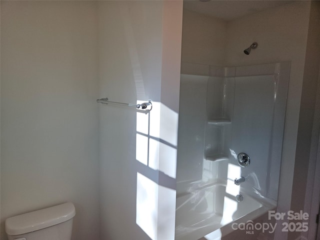 bathroom featuring a shower and toilet