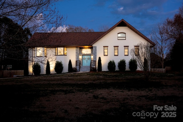 view of front of home with a front yard and stucco siding